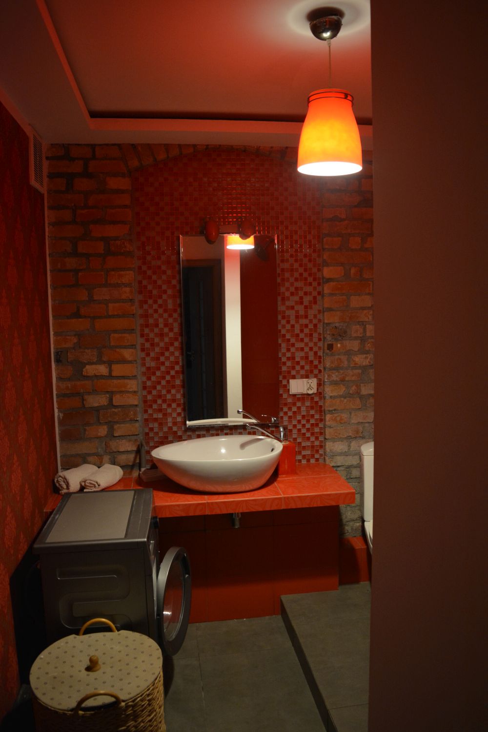 Apartament czerwony Poznań - sypialnia z ceglaną ścianą